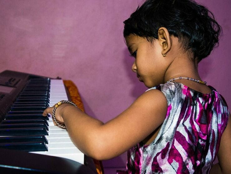 Toddler playing the piano at Movida Heights day care